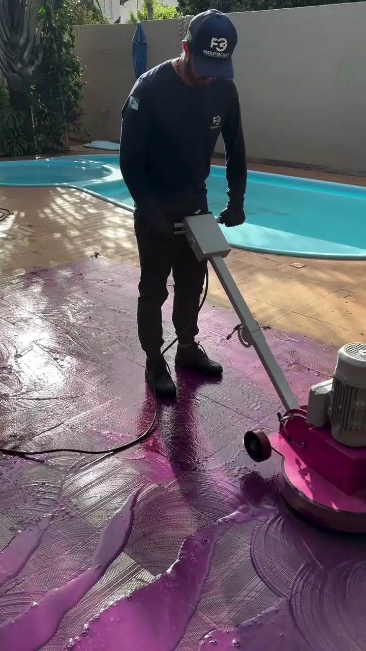 Enceradeira industrial rosa limpando o pátio ao lado da piscina