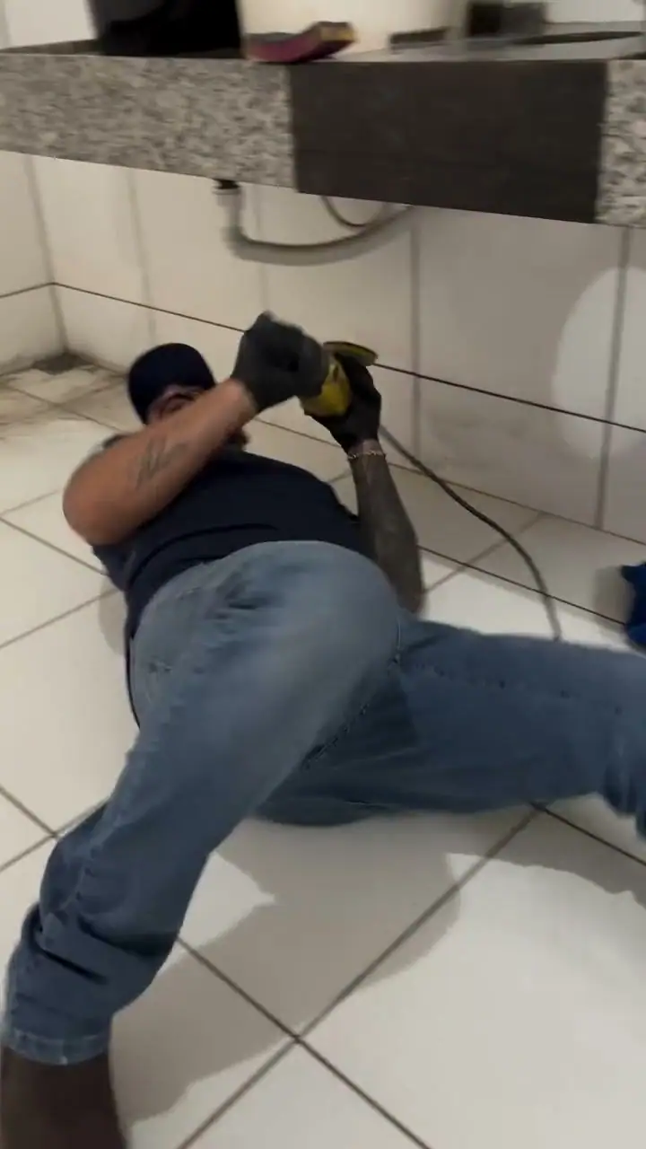 Profissional limpando embaixo da pia em limpeza pós-obra